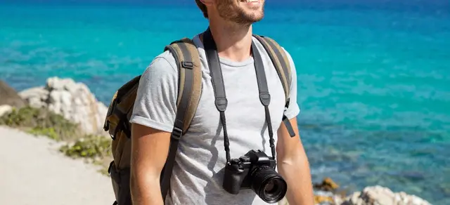 A traveller with a camera beside the sea